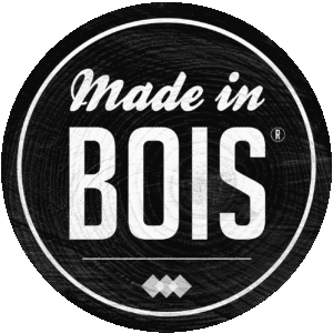 Emblème noir et blanc Made in BOIS®. Fond texturé grain de bois brut, typographie script et majuscule dans un cercle.